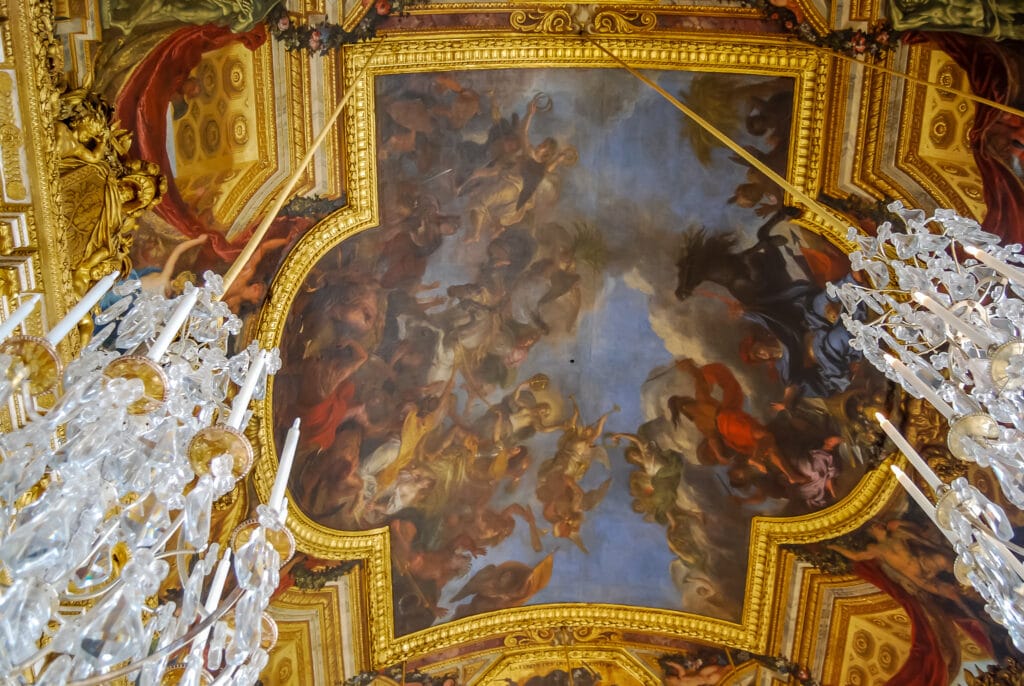 The colorful ceiling and the crystal chandeliers in the Hall of Mirrors at Versailles