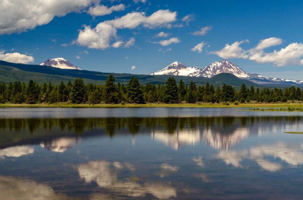 The Three Sisters mountains reflected in a small lake in the Willamette National Forest