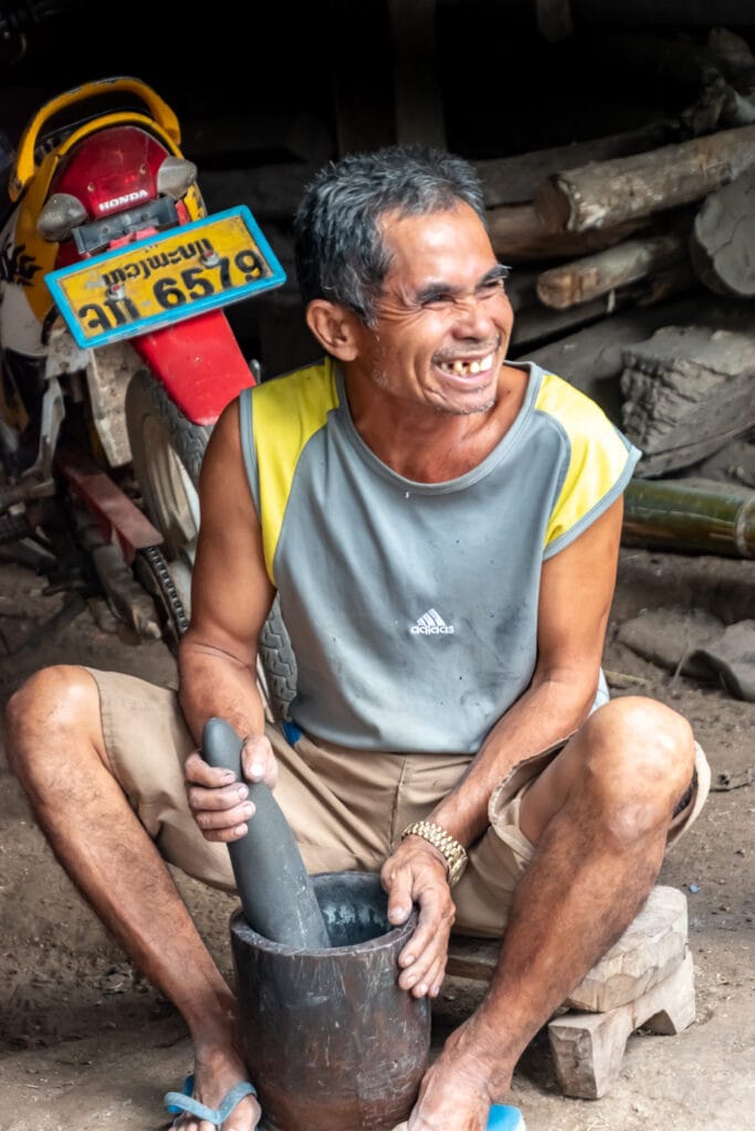 Laotian man grinding gunpowder