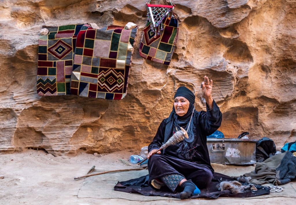 A Bedouin woman spins wool inside Little Petra