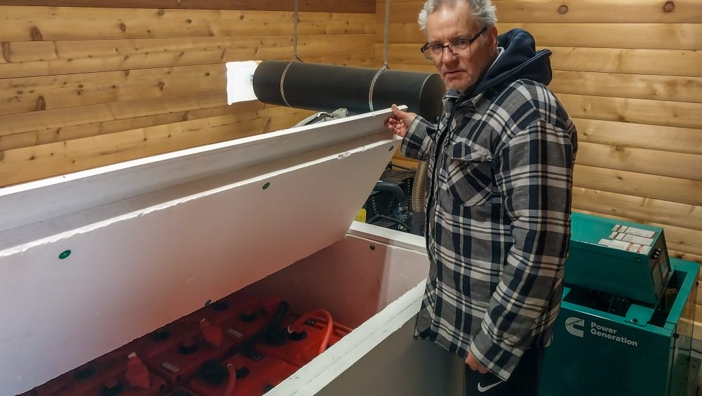 Meinrad proudly shows off his solar powered batteries and generator