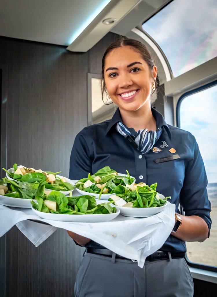 Hostess Olivia expertly serves the Pear, spinach, and Brie salad