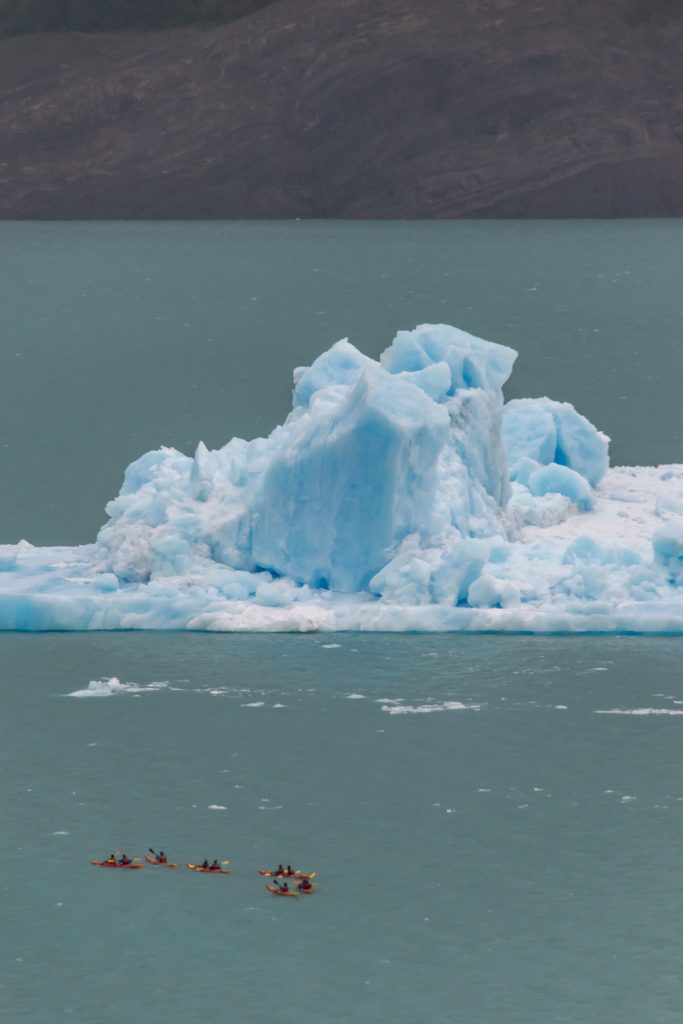 Close up view of kayakers and one of the ice bergs