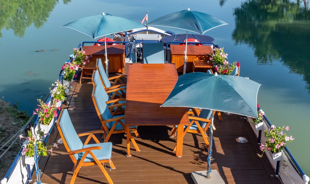 The sun deck with its table, chairs, and umbrellas